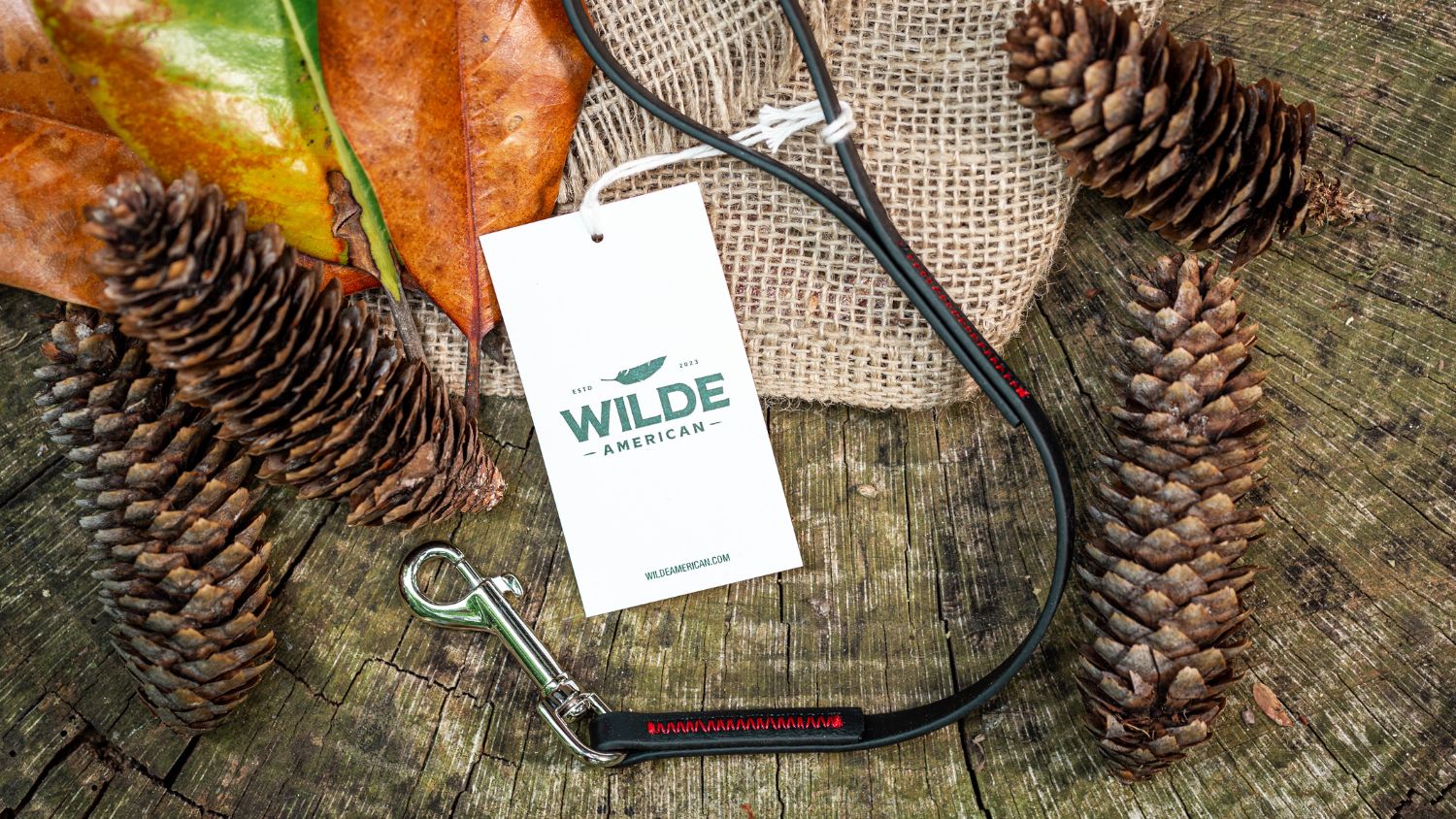 Wilde American Micro Leash Product Flatlay on wood elements surrounded by pinecones